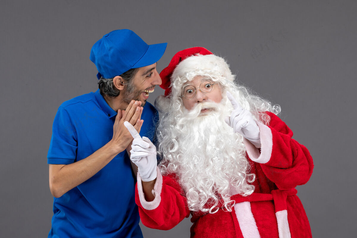 庆祝灰色墙上的圣诞老人和男信使的正面图男性服装十二月