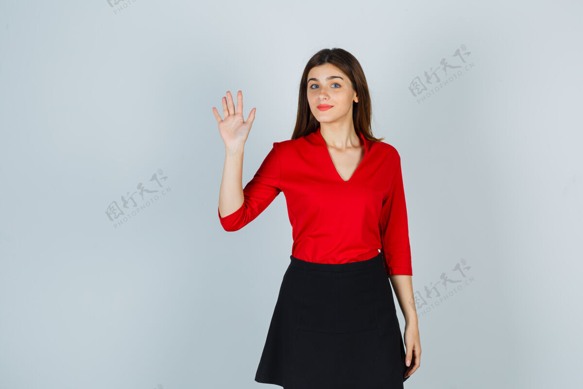 家穿红衬衫 黑裙子的年轻女子挥手致意 看上去很可爱室内小女性