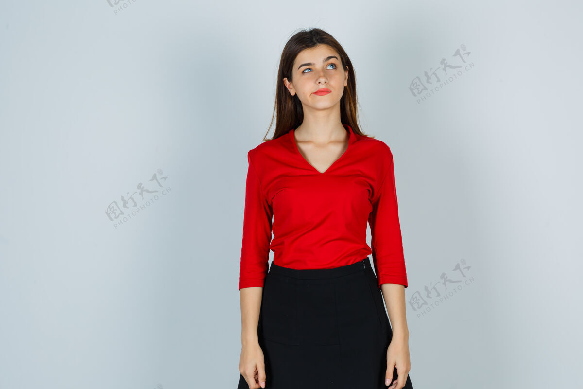 家穿着红衬衫 红裙子的年轻女士抬起头来 神情沉思思考工作咖啡