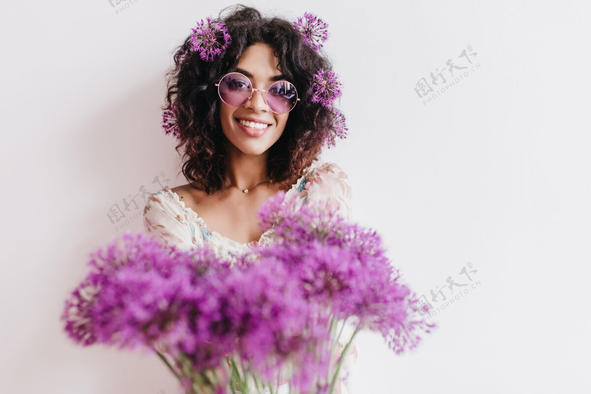 紫罗兰幸福的非洲女孩微笑着摆出美丽的花束室内拍摄的快乐的黑发女士孤立花美丽女士