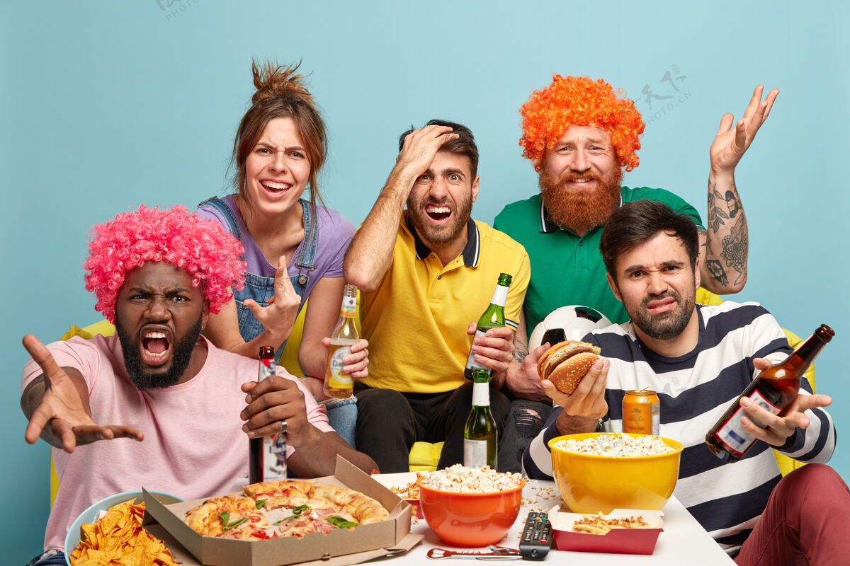 失望失望的四男一女观看体育比赛 不满球队失败 喝啤酒 吃零食 表达负面反应 情绪不好 在家沙发上摆姿势球队输了足球玩女人