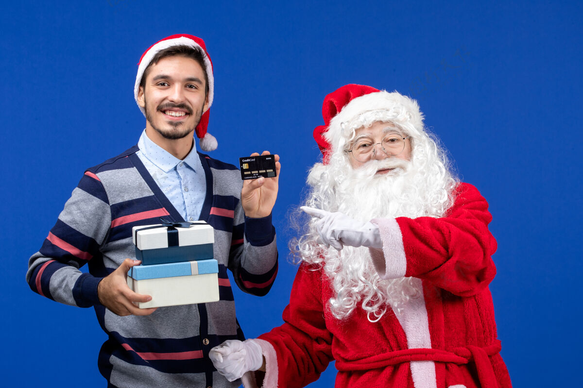 服装正面图：圣诞老人和手持礼物的年轻男性快乐节日礼物