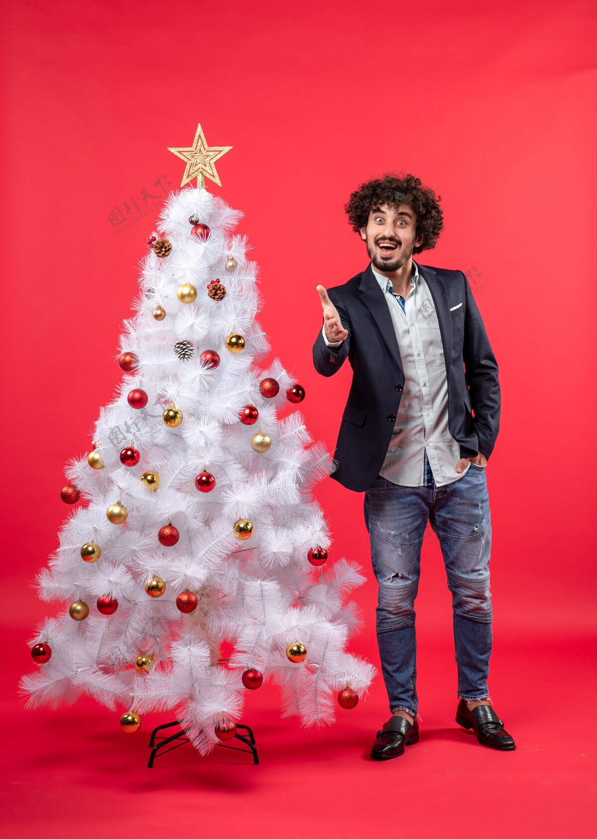肖像圣诞庆祝与快乐有趣的年轻人欢迎某人站在圣诞树附近快乐成人时尚