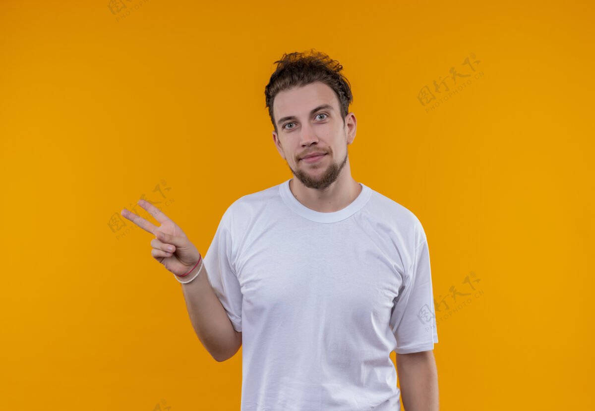 穿着高兴的年轻人穿着白色t恤 在孤立的橙色背景上显示和平姿态高兴白色手势