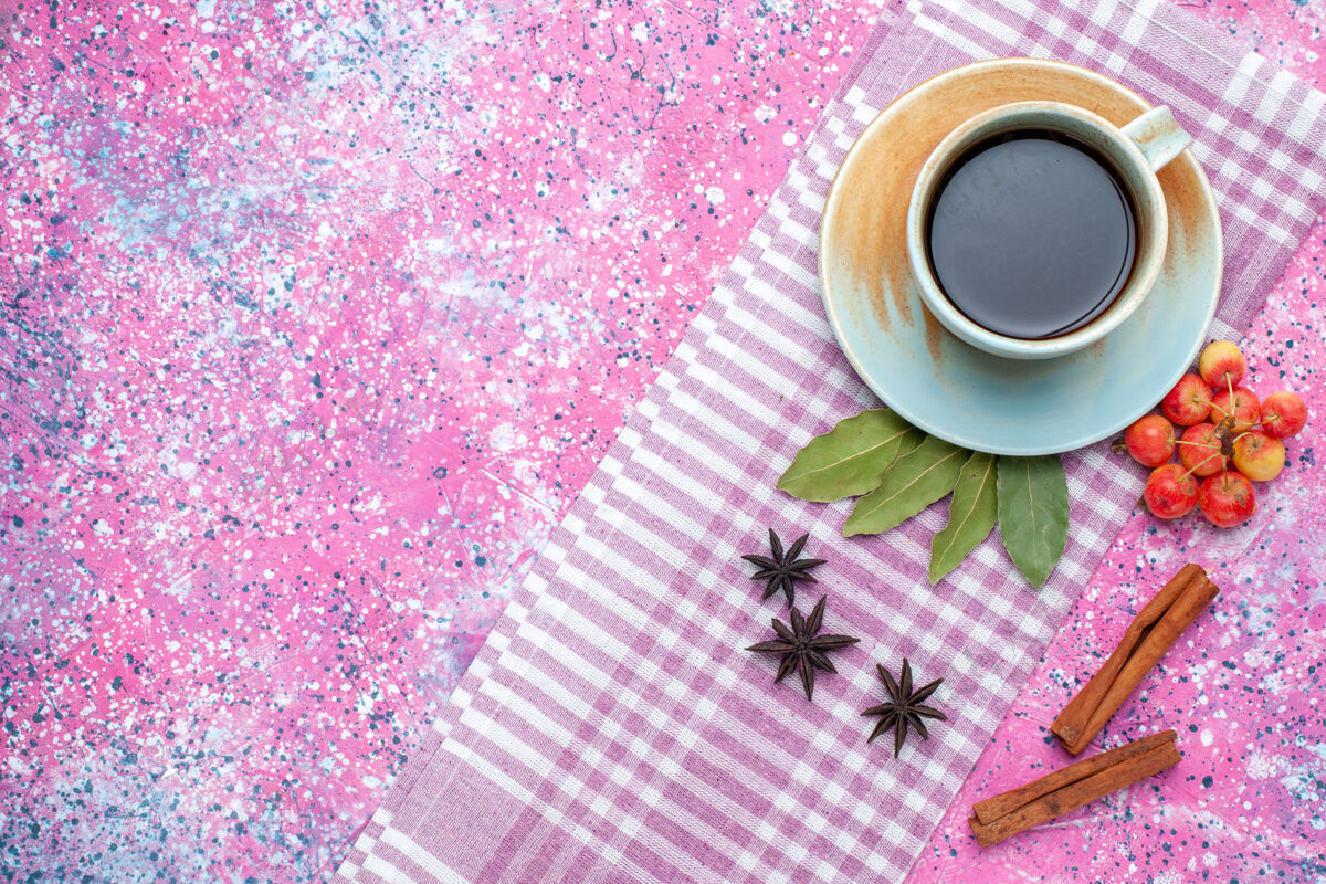 饮料顶视图一杯茶与肉桂和樱桃在粉红色的背景上喝水果色的茶茶碟樱桃水果
