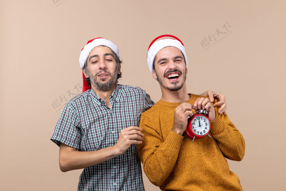 两个快乐的男人正面图两个快乐的男人一个把手放在朋友的肩膀上 背景是米色的两个风景前面