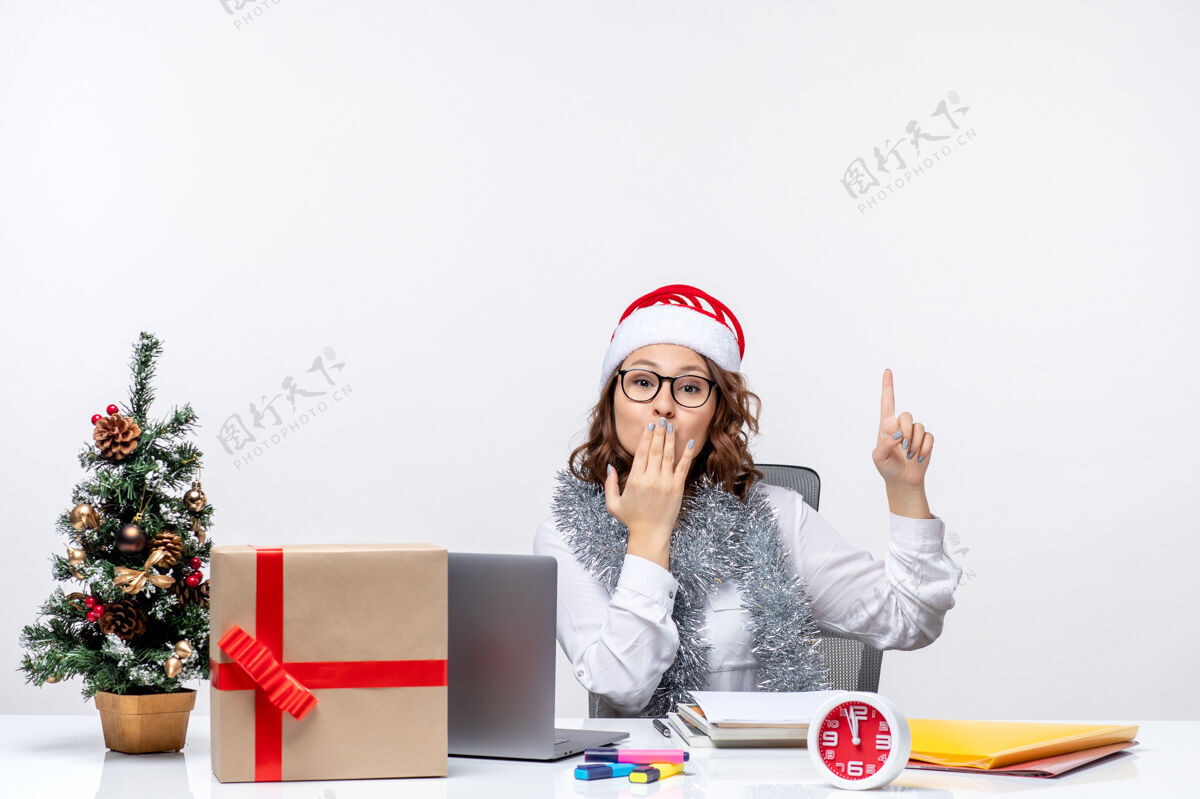 办公室正面图：年轻女工坐在她工作的地方前 在白色的背景上亲吻坐着工作亲吻