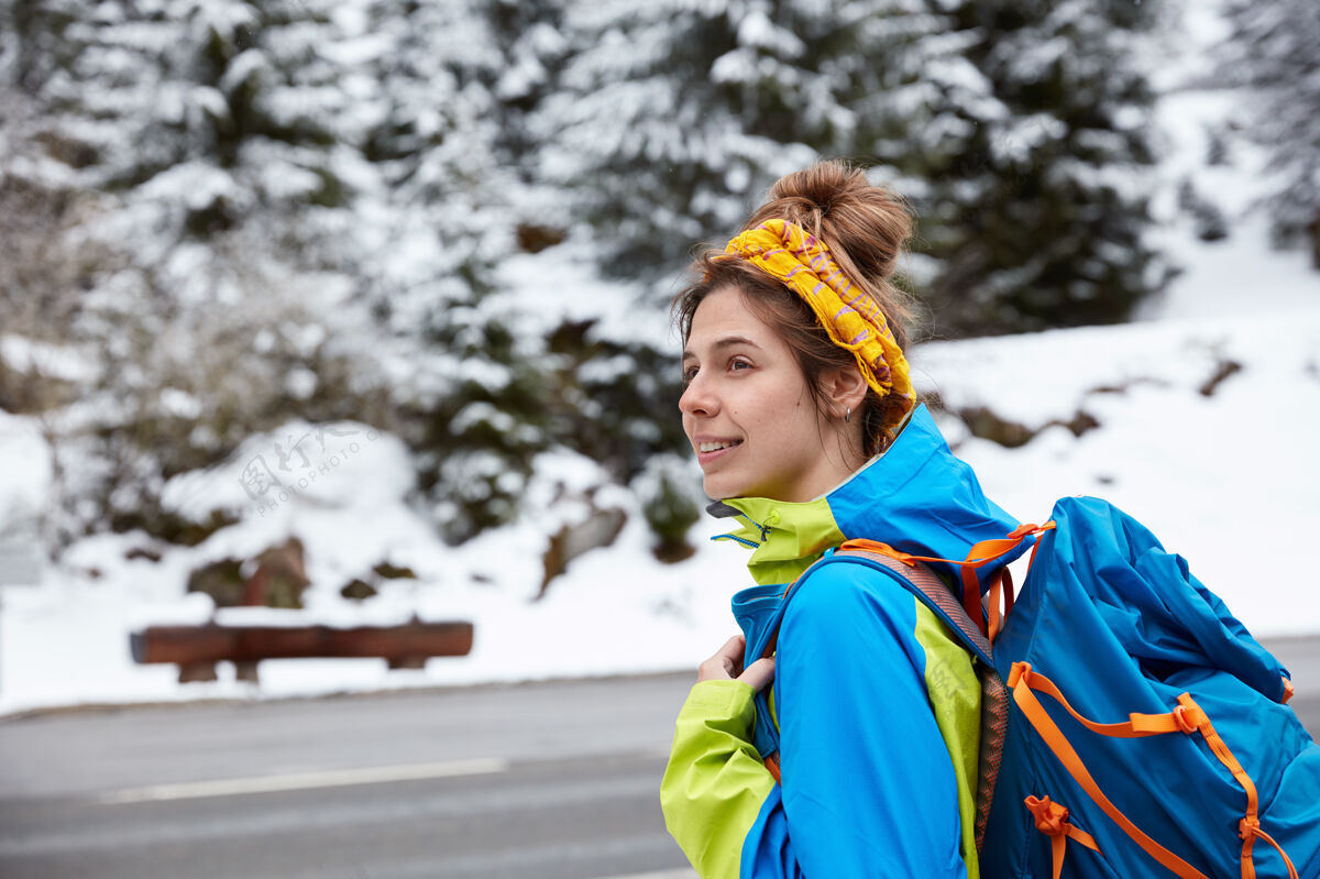 岩石体贴的欧洲女人专注在一边 冬天在雪山附近散步和跋涉 欣赏风景探索摆姿势路