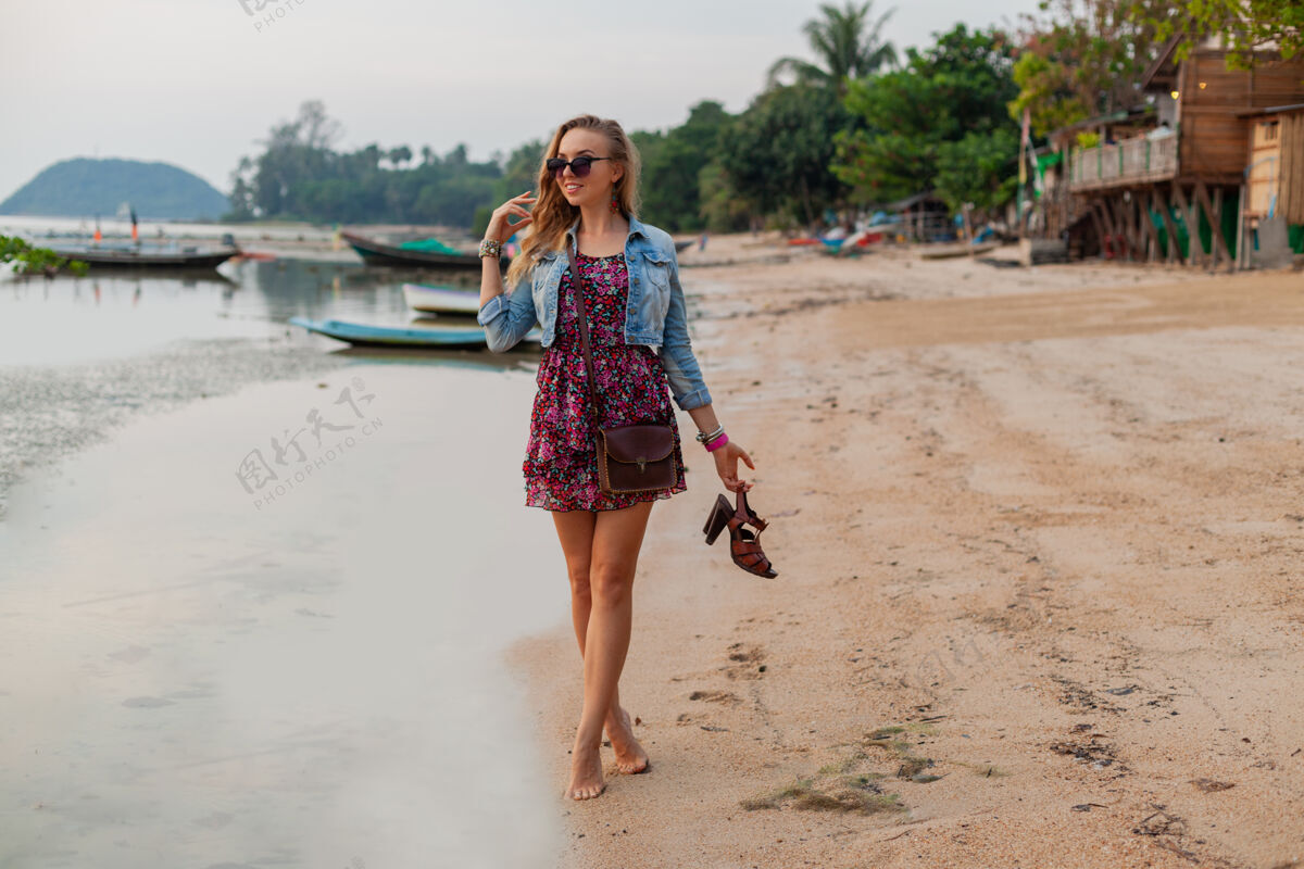 美丽时尚的女人在夏天穿着度假鞋走在沙滩上夏天年轻乐趣
