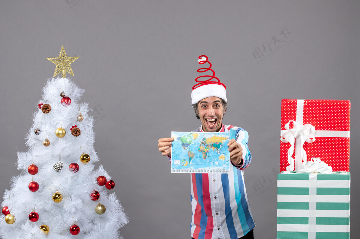 春天正面图快乐男子戴着螺旋弹簧圣诞帽高举世界地图看举行假期帽子