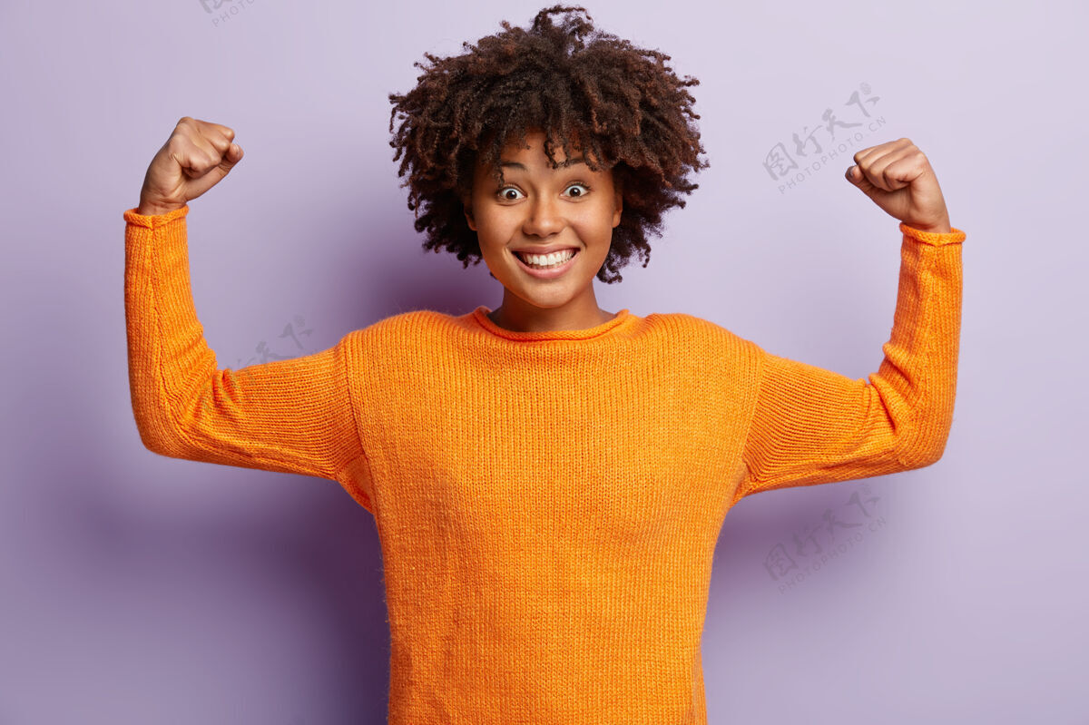 欣喜若狂是的 我是赢家快乐微笑的黑皮肤女人举起双臂 展示肌肉 强大胜利非洲力量