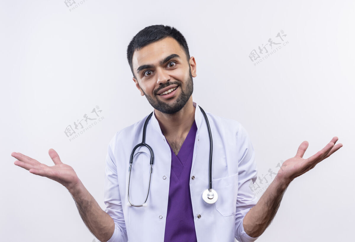 医生微笑的年轻男医生穿着听诊器医用长袍 在孤立的白色背景上展开双手医疗传播白色