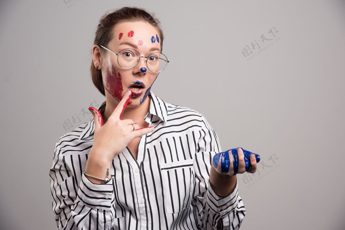 绘画脸上涂着颜料 戴着灰色背景眼镜的女人女性肮脏凌乱