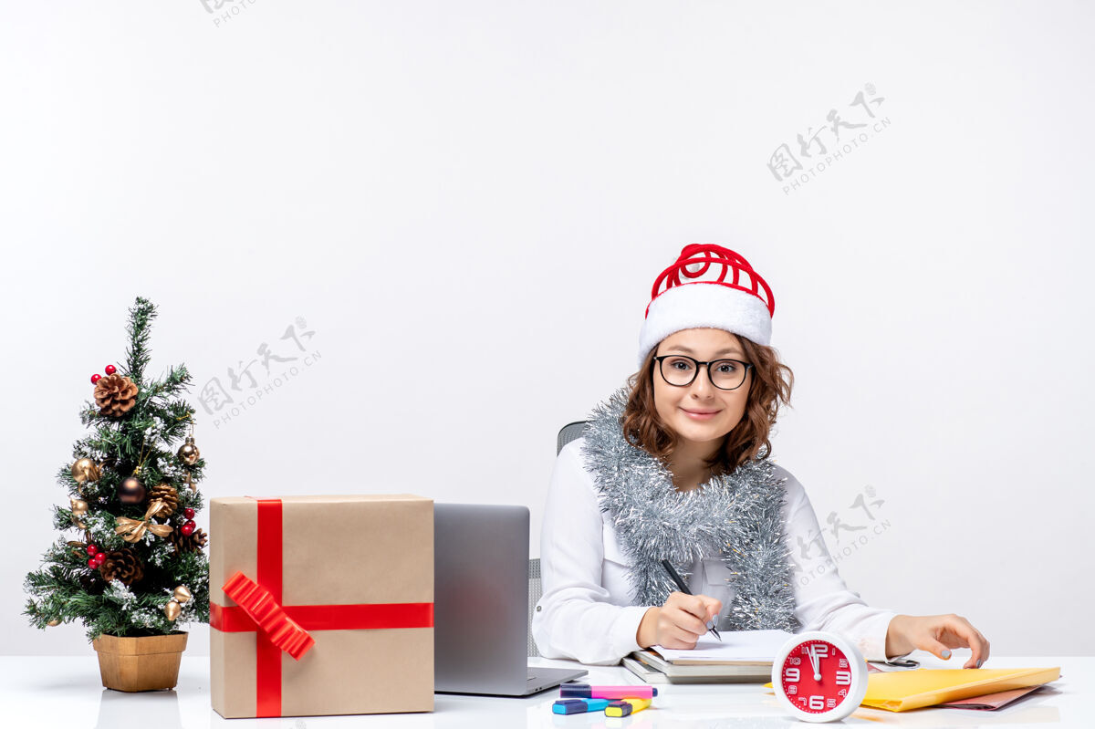 年轻女性工作场所的年轻女性在白色背景上写笔记女士前面坐着