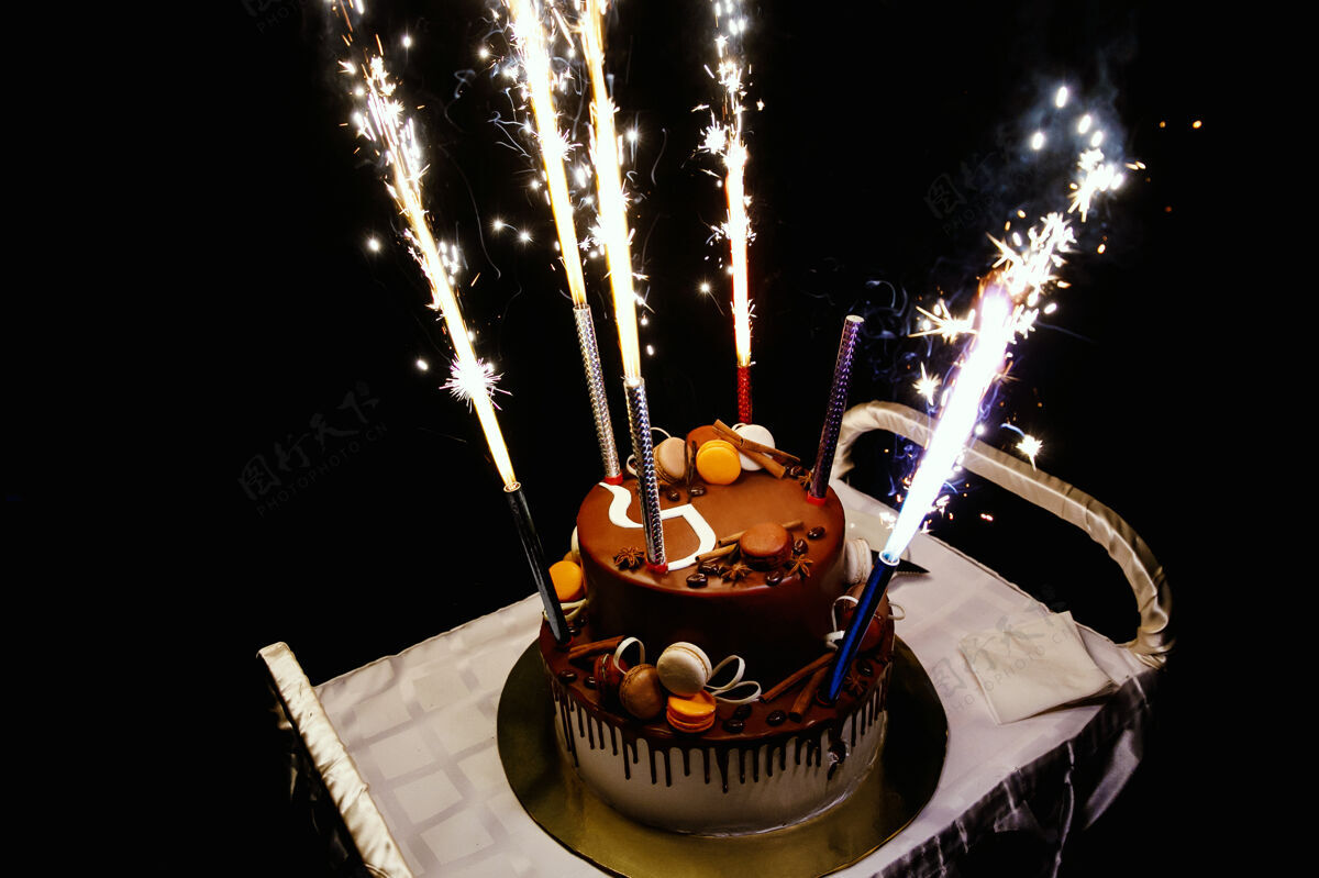 五颜六色生日蛋糕放在黑色的桌子上蛋糕快乐火