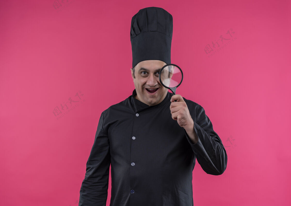 中年惊讶的中年男厨师穿着厨师制服拿着放大镜和复印空间厨师放大镜男