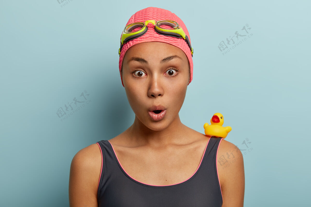 害怕震惊的非裔美国女性头像有暑假休息 戴着护目镜和泳衣女凝视小鸭