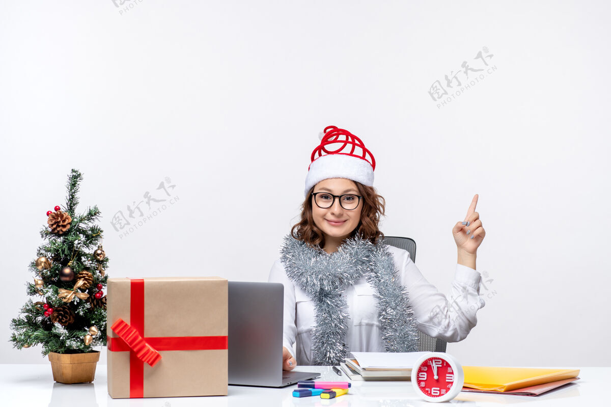 商务正面图：年轻的女工坐在白色背景的工作场所前礼物风景坐着