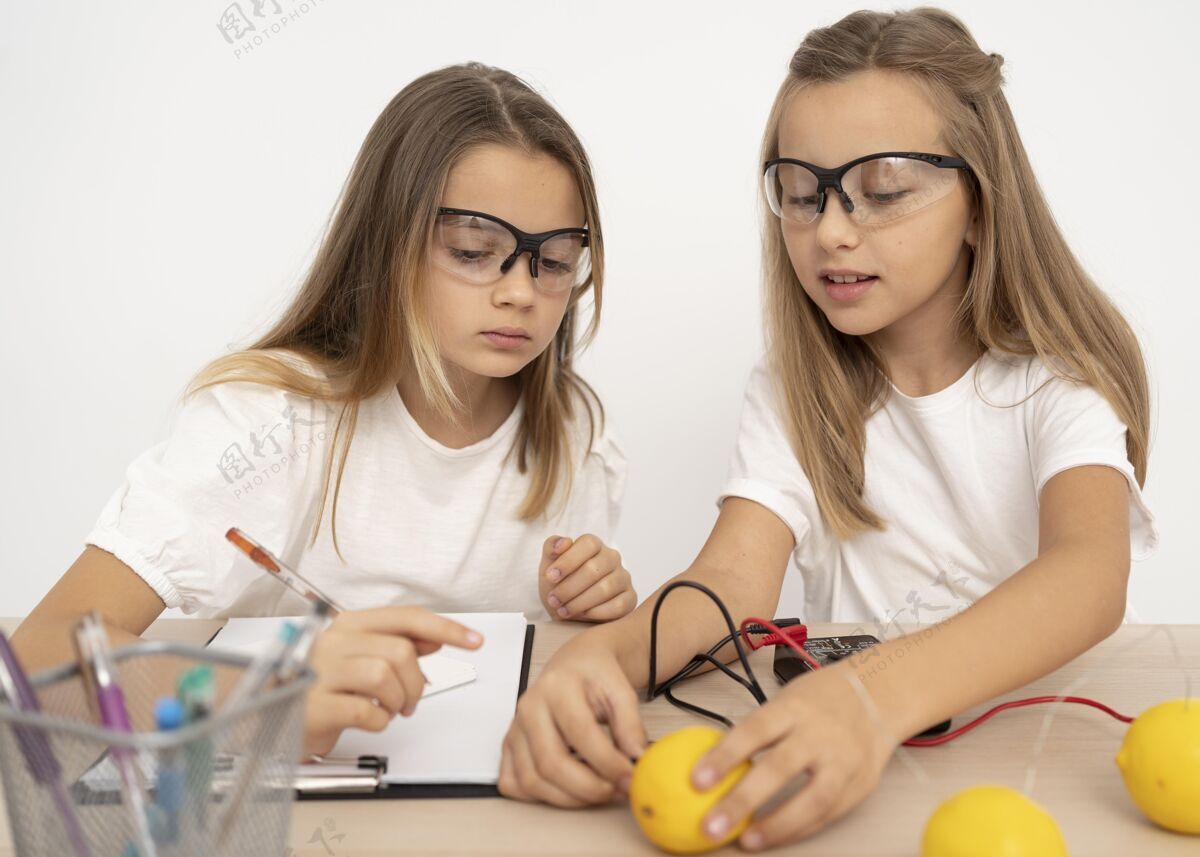 安全眼镜两个女孩用柠檬做科学实验柠檬乐趣学校