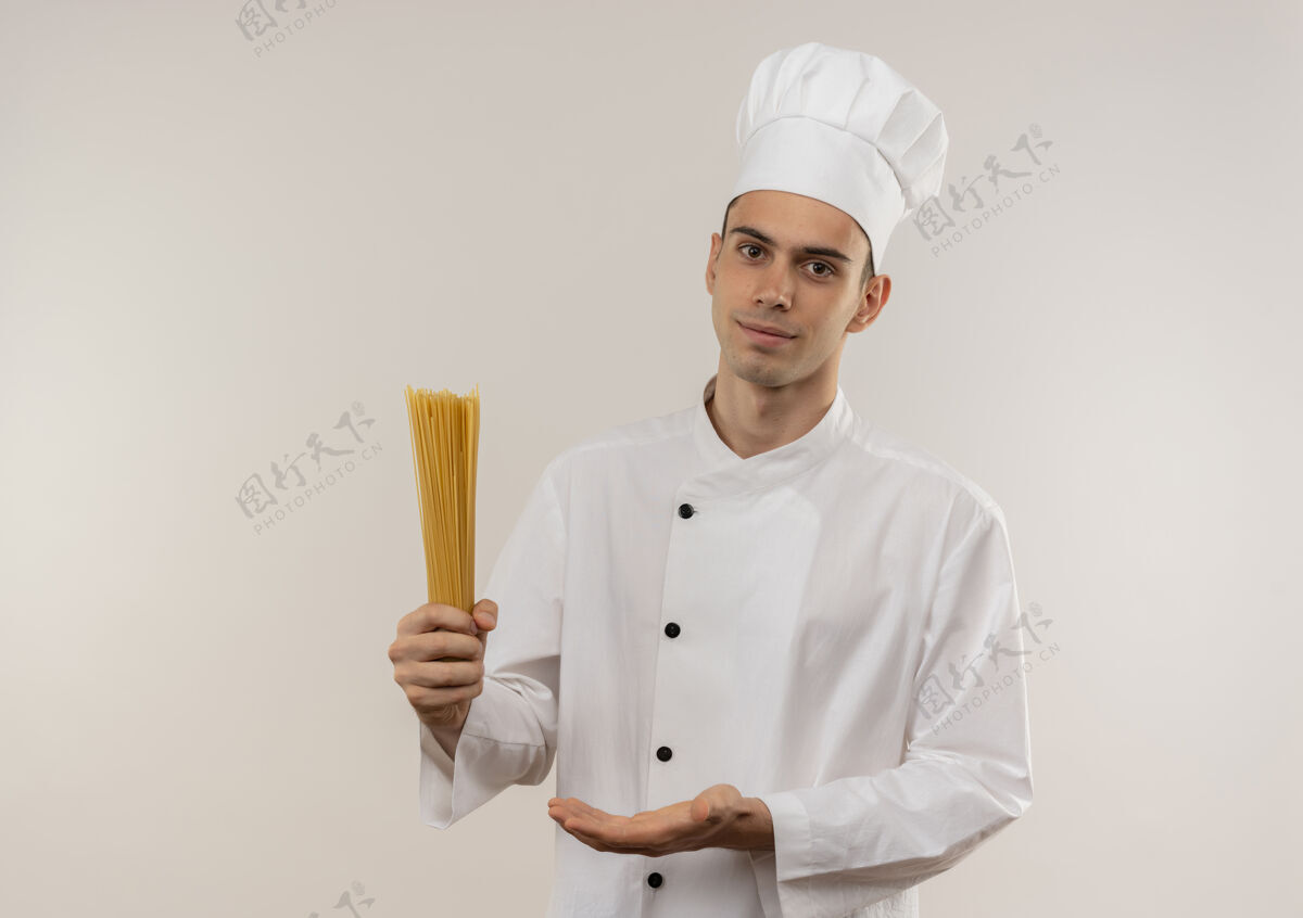 制服高兴的年轻男厨师穿着厨师制服显示意大利面在他的手与复制空间展示高兴男