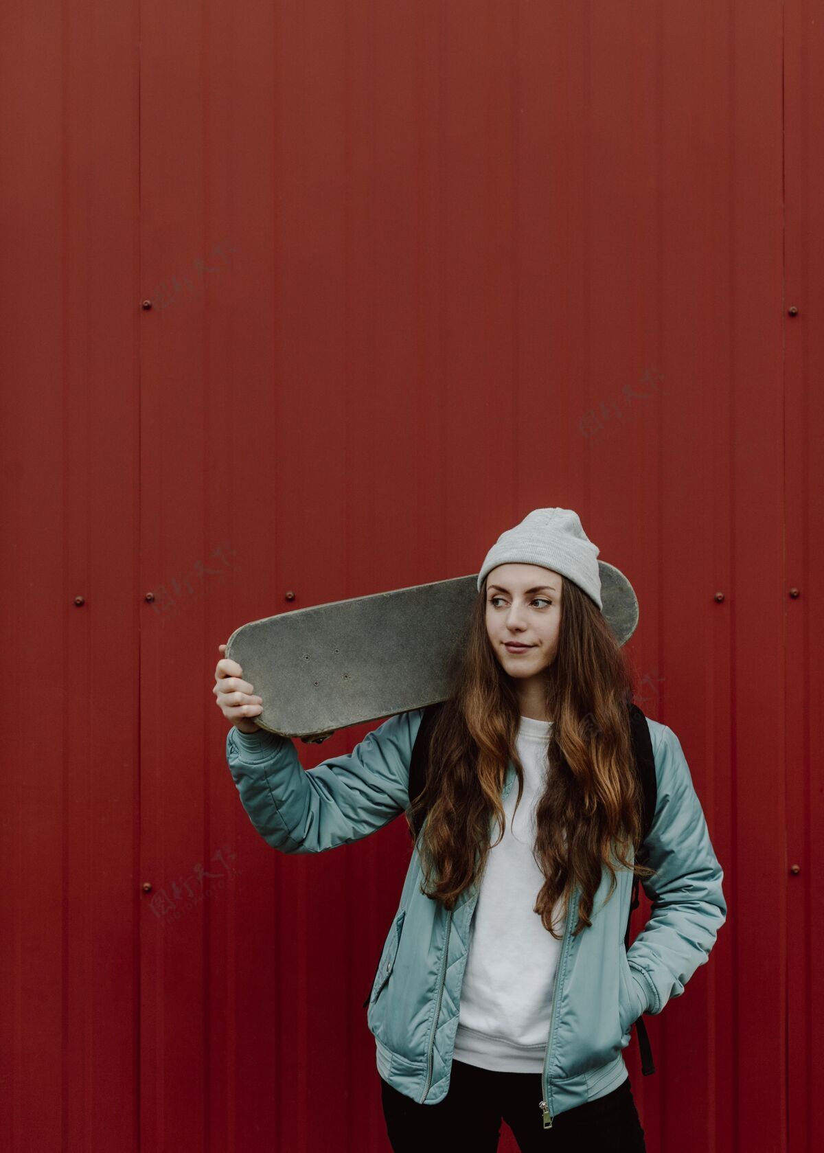 运动滑板女孩和她的滑板在城市里练习城市滑板