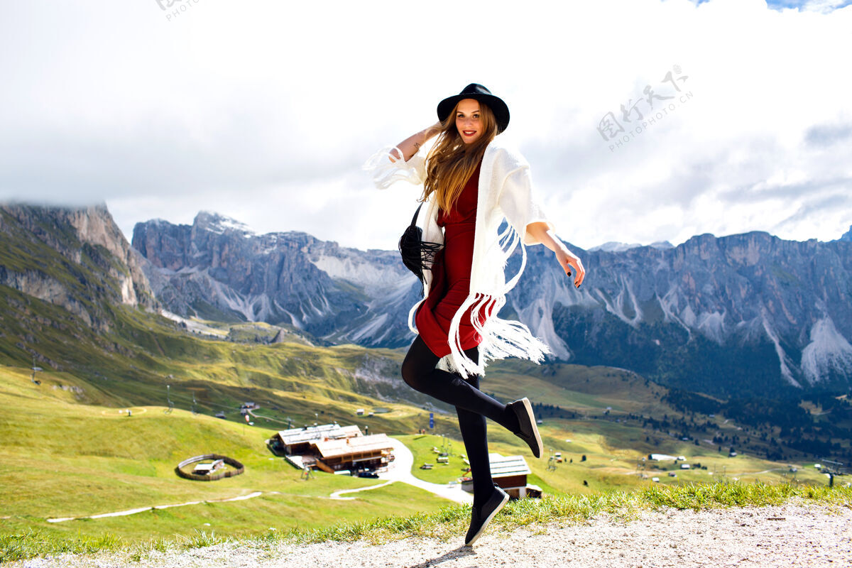 游客年轻时尚的女子在阿尔卑斯山摆出波西米亚式的时装造型夏天帽子山