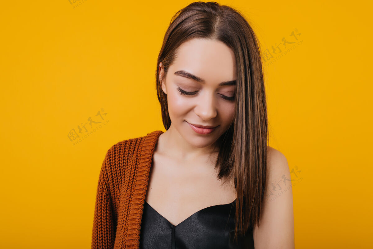 人迷人的黑发女孩带着害羞的微笑摆姿势的特写照片漂亮的直发女模特的肖像黄色欧洲年轻